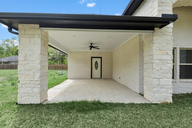 entrance to property featuring a lawn and ceiling fan