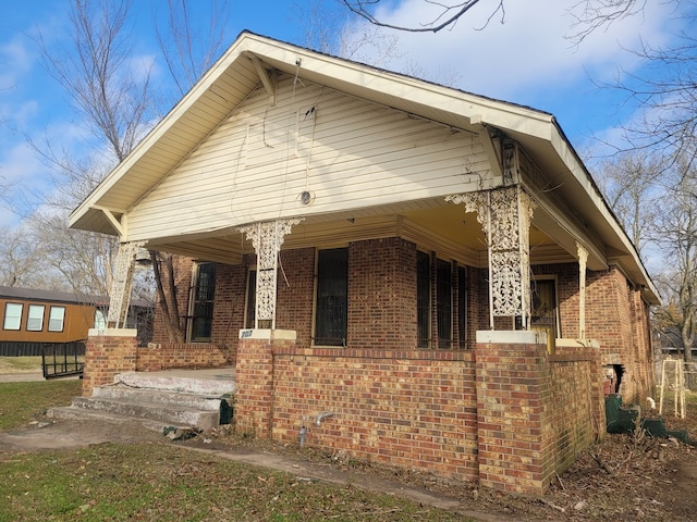 view of side of home featuring covered porch