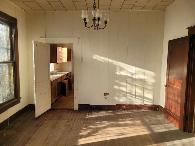 spare room featuring a notable chandelier and dark hardwood / wood-style floors