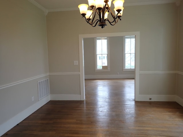 unfurnished room featuring a chandelier, crown molding, and dark hardwood / wood-style flooring