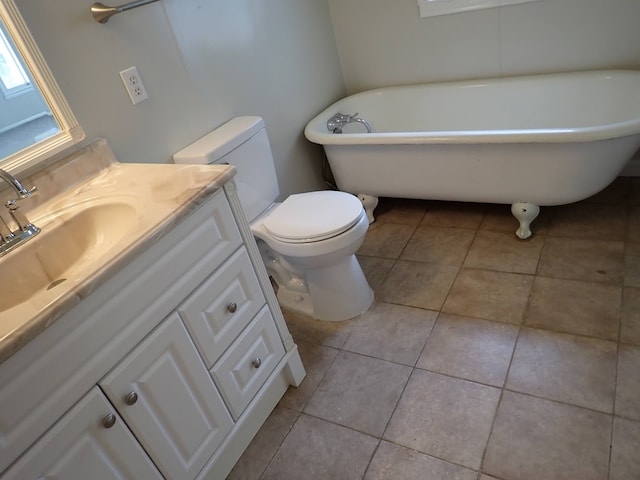 bathroom with a bathtub, toilet, vanity, and tile flooring