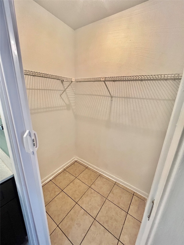 spacious closet with light tile patterned floors