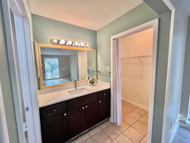 bathroom featuring vanity, tile patterned flooring, and a textured ceiling