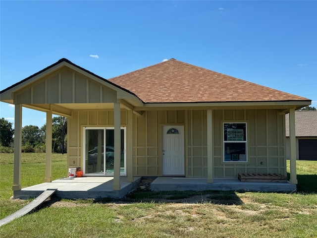 rear view of property with a lawn