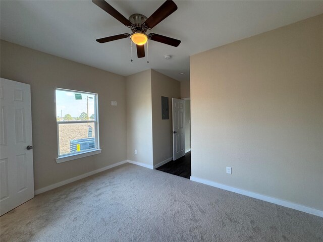 spare room featuring ceiling fan and dark colored carpet