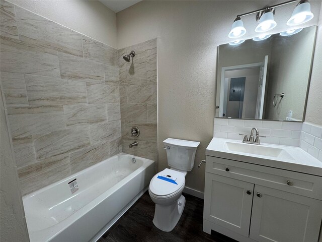 full bathroom featuring backsplash, tiled shower / bath combo, hardwood / wood-style floors, vanity, and toilet