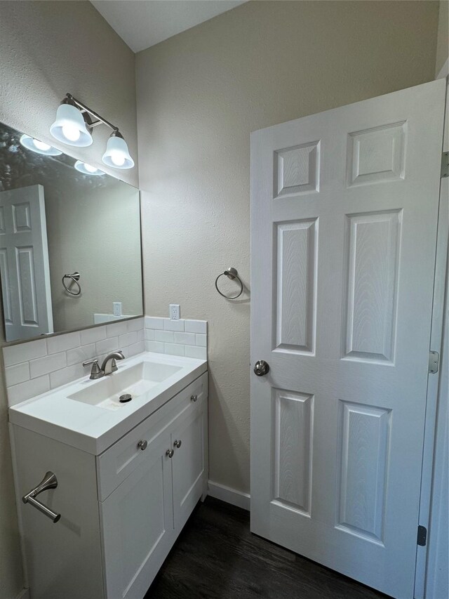 bathroom with vanity, wood-type flooring, and backsplash