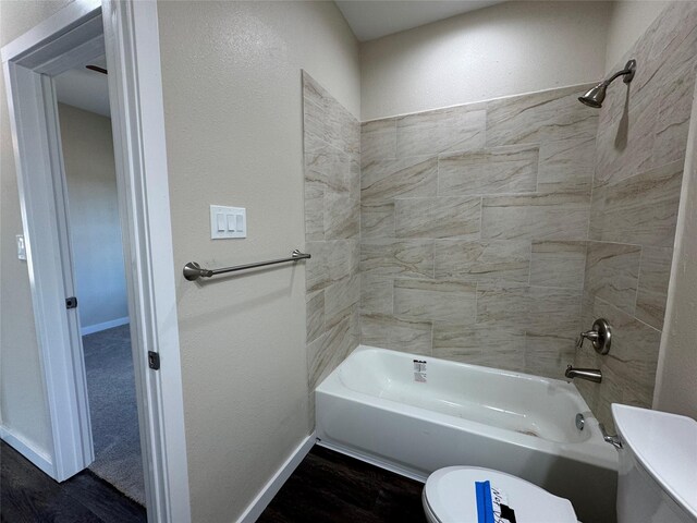 bathroom featuring tiled shower / bath and toilet