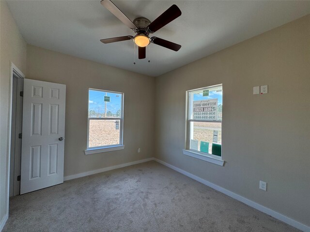 carpeted empty room featuring ceiling fan