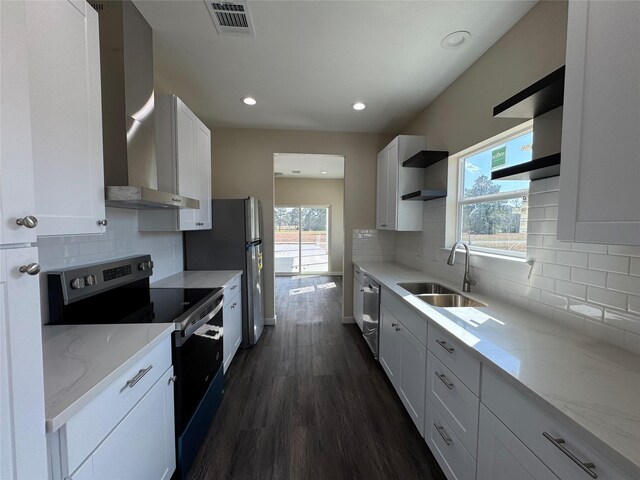 kitchen featuring wall chimney exhaust hood, stainless steel appliances, sink, and white cabinets