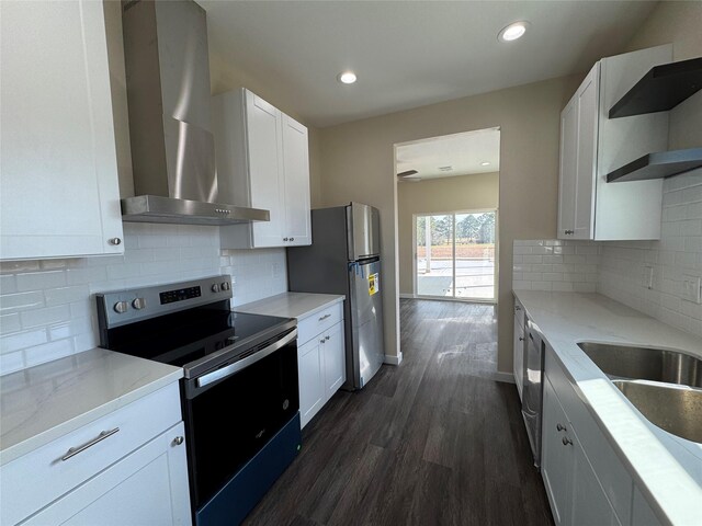 kitchen featuring stainless steel appliances, light stone countertops, wall chimney range hood, and white cabinets