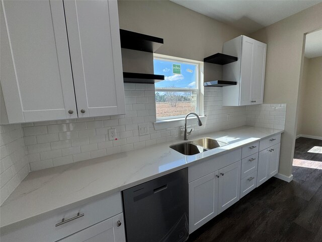 kitchen with dishwashing machine, sink, light stone counters, and white cabinets