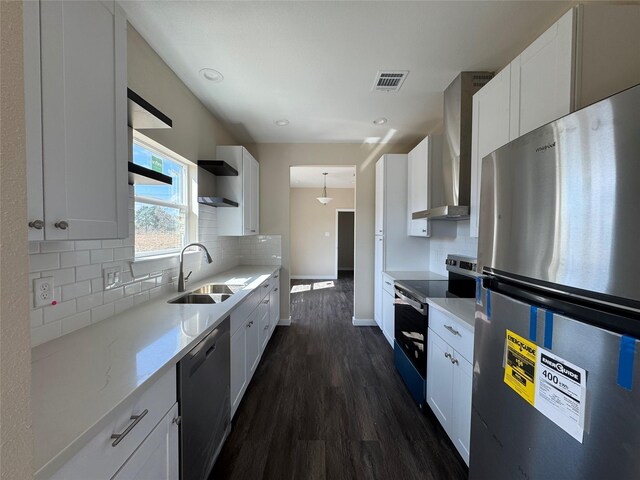 kitchen featuring white cabinetry, appliances with stainless steel finishes, and wall chimney range hood