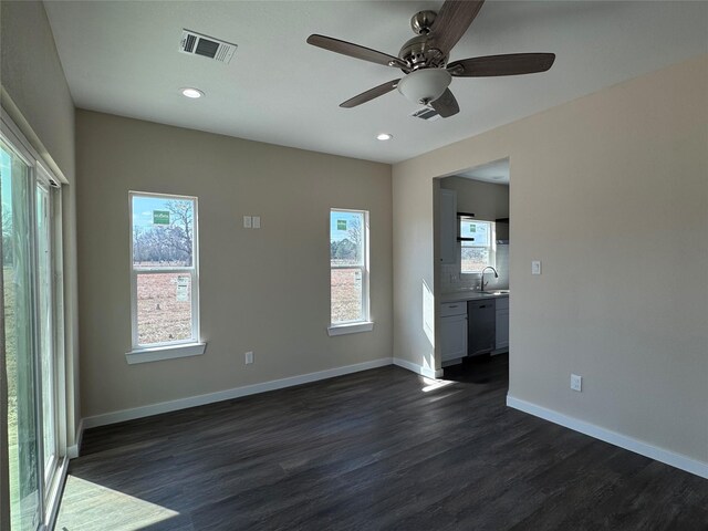 unfurnished living room with dark wood-type flooring, sink, and ceiling fan