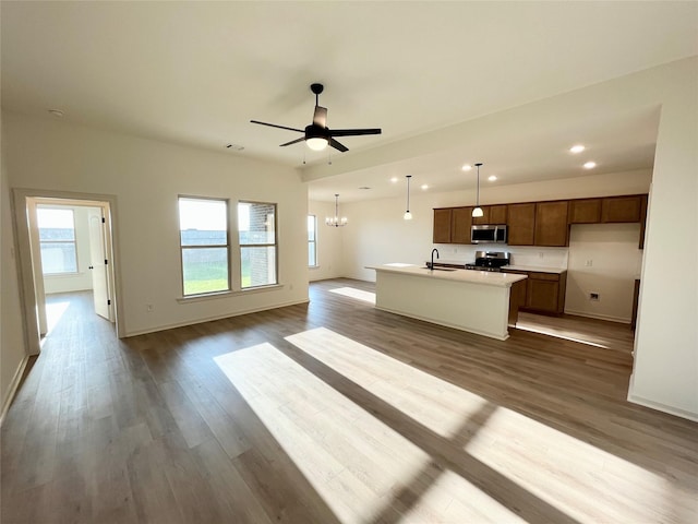 726 Blue Sky Pl, Beasley, TX 77417 - kitchen with stainless steel appliances, open floor plan, an island with sink, a sink, and dark wood-style floors