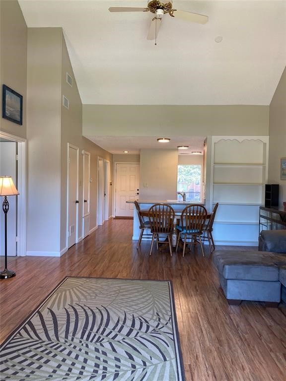 dining space featuring dark hardwood / wood-style floors, ceiling fan, and lofted ceiling