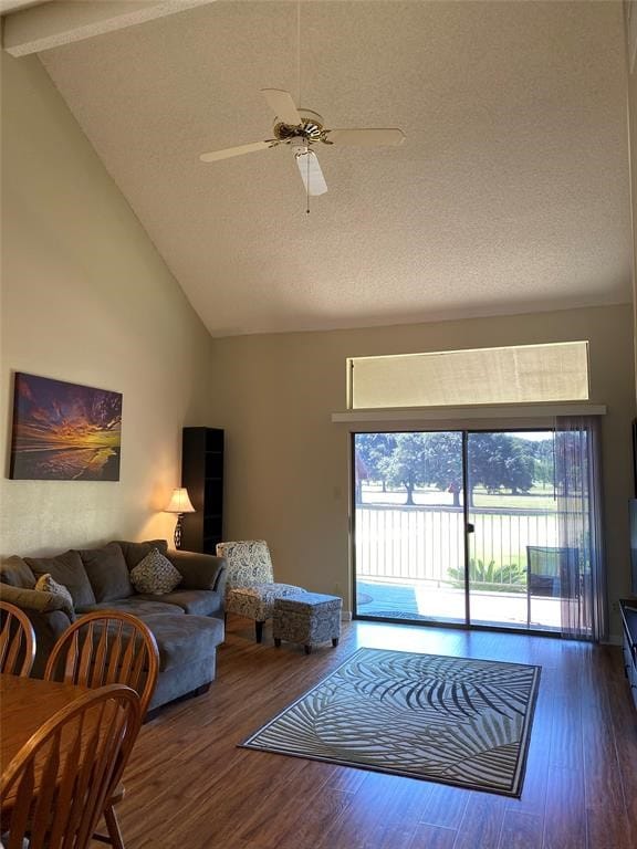 living room featuring dark hardwood / wood-style flooring, ceiling fan, beam ceiling, and high vaulted ceiling