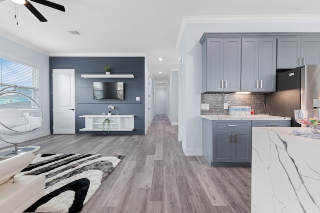 kitchen with stainless steel refrigerator, ceiling fan, backsplash, gray cabinetry, and light hardwood / wood-style flooring