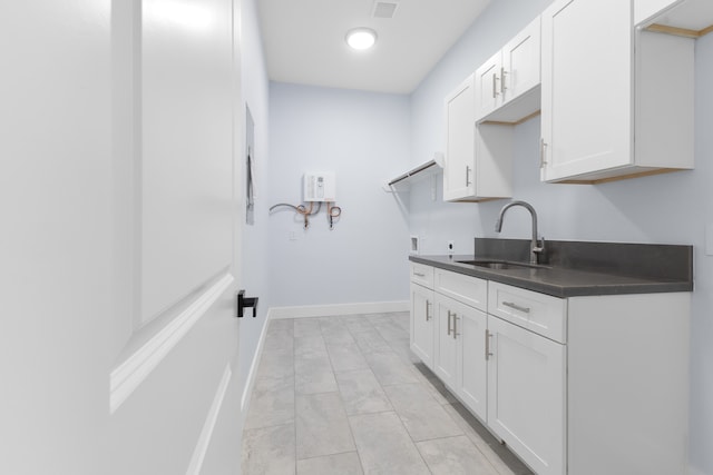 clothes washing area featuring washer hookup, cabinets, sink, and light tile flooring