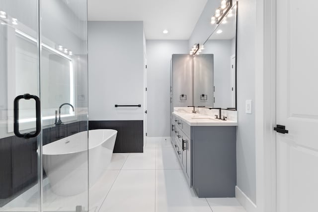 bathroom featuring tile floors, dual vanity, and a bathtub