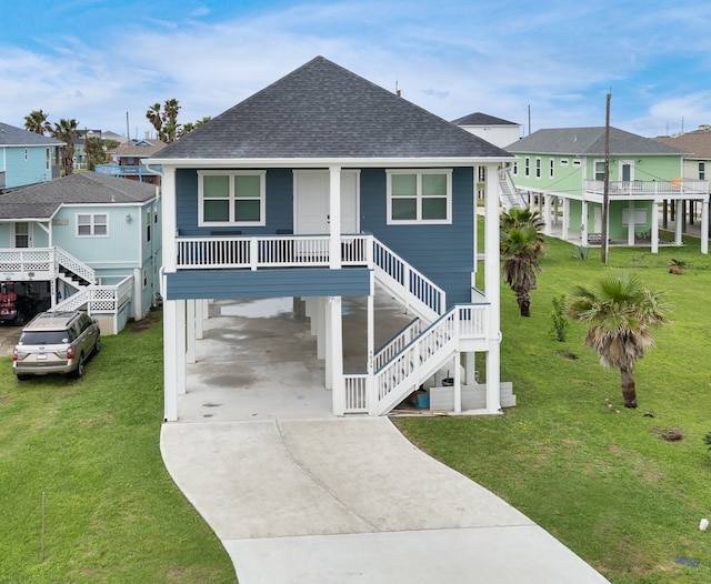 raised beach house featuring a front lawn, a carport, and a porch