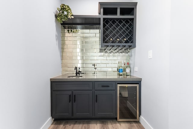 bar with sink, gray cabinetry, hardwood / wood-style floors, backsplash, and wine cooler