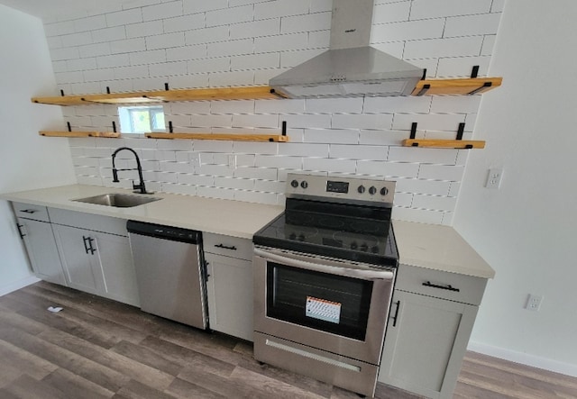 kitchen with sink, dark hardwood / wood-style flooring, appliances with stainless steel finishes, extractor fan, and backsplash