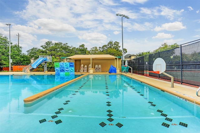 view of pool featuring a playground and a water slide