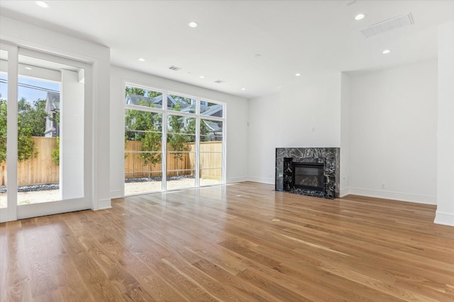 unfurnished living room featuring light hardwood / wood-style flooring and a premium fireplace