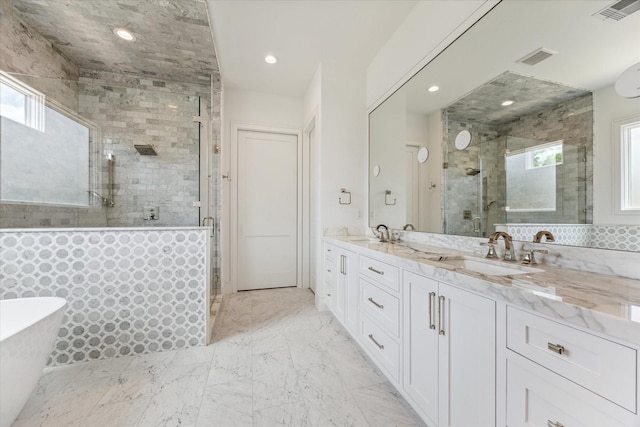 bathroom featuring a wealth of natural light, independent shower and bath, and vanity