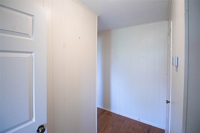 corridor with a textured ceiling and dark hardwood / wood-style flooring