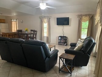 living room with ceiling fan and light tile flooring