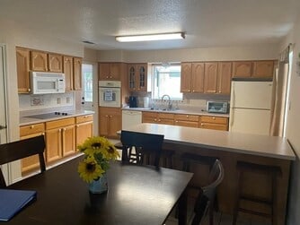 kitchen featuring a kitchen bar, sink, and white appliances