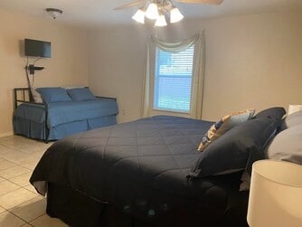 bedroom featuring ceiling fan and light tile flooring