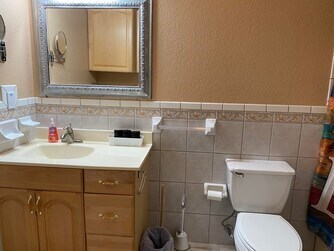 bathroom featuring backsplash, tile walls, vanity, and toilet