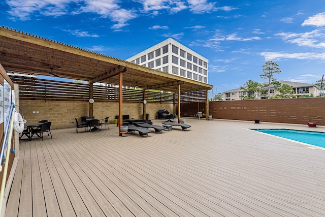 wooden terrace featuring a fenced in pool and a pergola