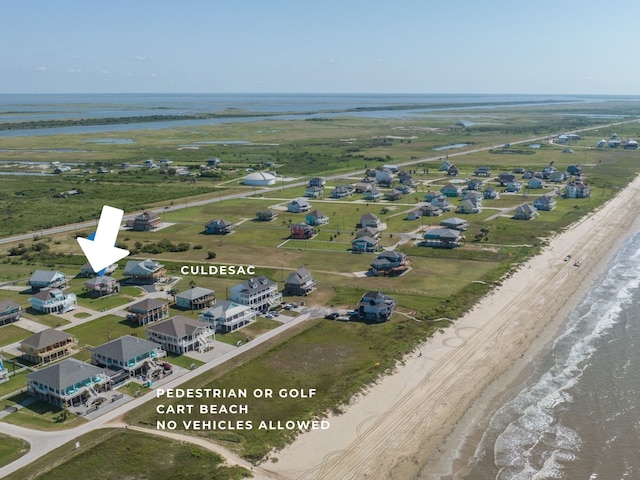 birds eye view of property with a water view and a beach view