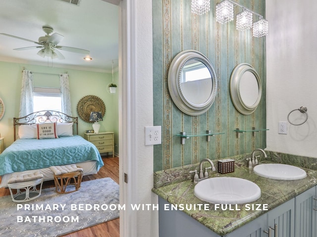 bathroom featuring vanity, hardwood / wood-style flooring, ceiling fan, and ornamental molding