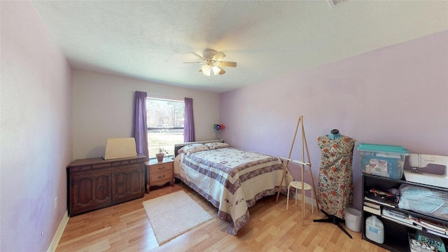 bedroom with baseboards, a ceiling fan, and light wood-style floors