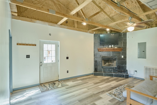 living room with a fireplace, electric panel, and light wood-type flooring