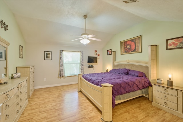 bedroom featuring light hardwood / wood-style floors, vaulted ceiling, and ceiling fan