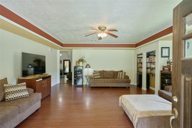 living room with dark wood-style flooring, a ceiling fan, and baseboards