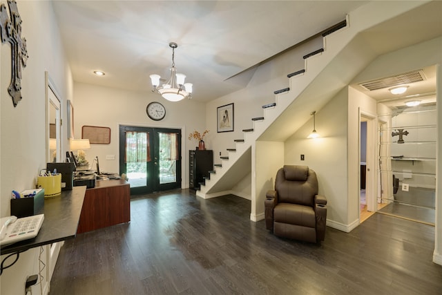 entrance foyer with an inviting chandelier, french doors, and dark wood-type flooring