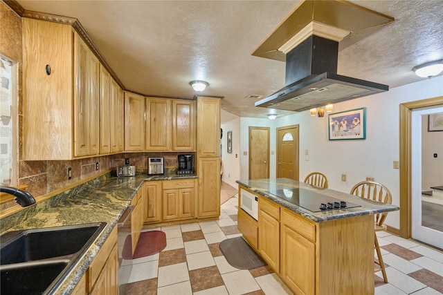 kitchen with sink, a kitchen island, decorative backsplash, island exhaust hood, and light tile patterned flooring