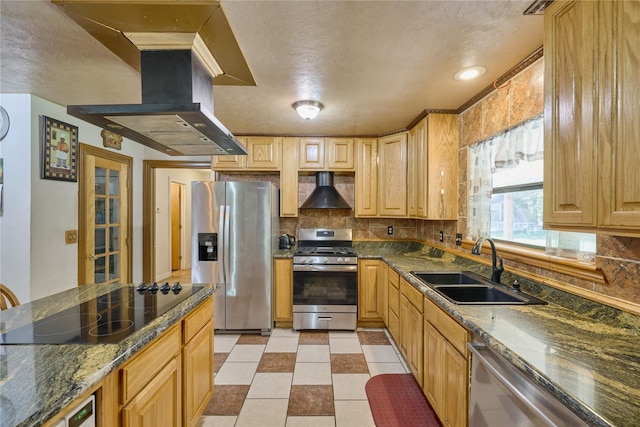 kitchen featuring island exhaust hood, stainless steel appliances, backsplash, a sink, and wall chimney range hood