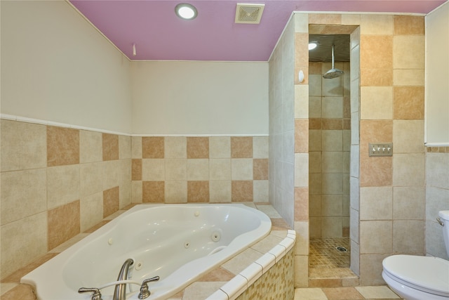 bathroom with tile walls, separate shower and tub, tile patterned floors, and toilet