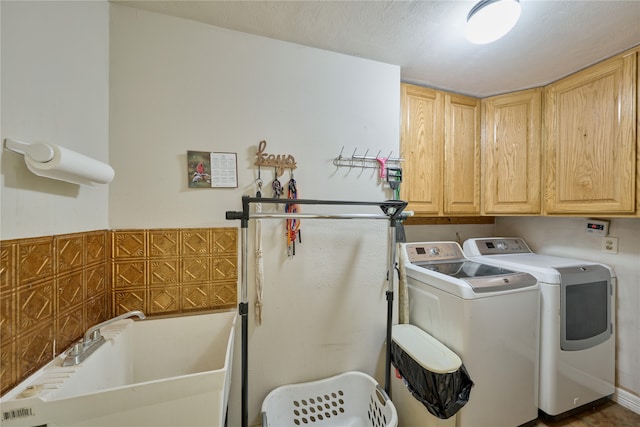 laundry area with washing machine and clothes dryer and cabinets