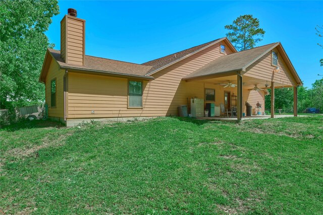 rear view of property with a patio, ceiling fan, and a yard