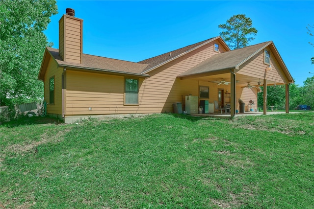 back of property featuring a yard, a chimney, a ceiling fan, and a patio