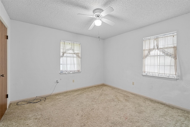 carpeted spare room featuring ceiling fan and a textured ceiling